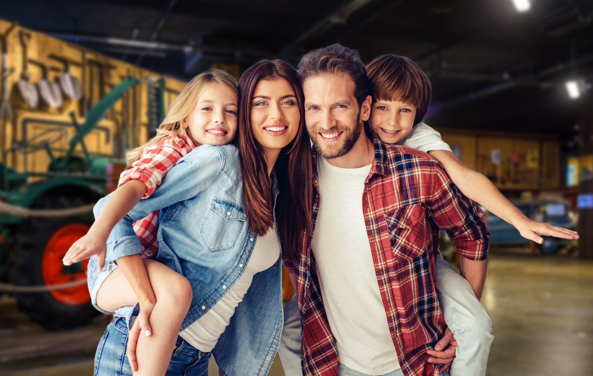 Eine Mama, ein Papa ein Mächen und ein Junge lächeln in die Kamera.