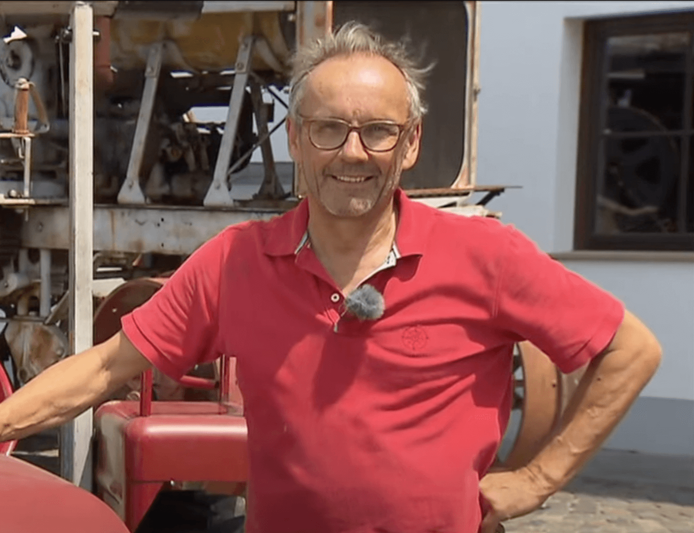 Ein Herr mit roten Polo-Shirt lächelt in die Kamera