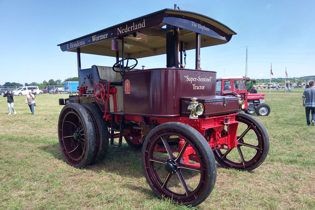 weinroter Super Tractor vom Hersteller Sentinel steht auf einer Wiese.