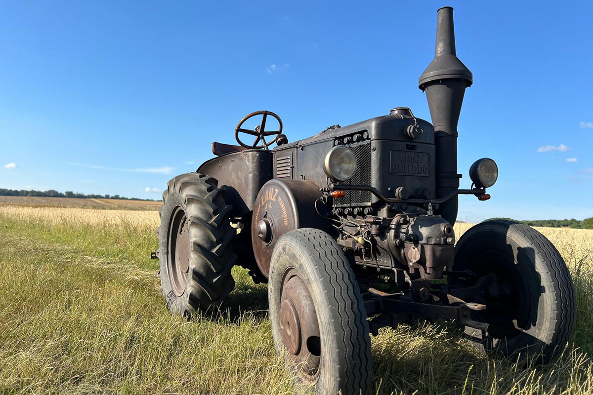 Ein Lanz Bulldog D9506 in Patina steht auf einem Feld