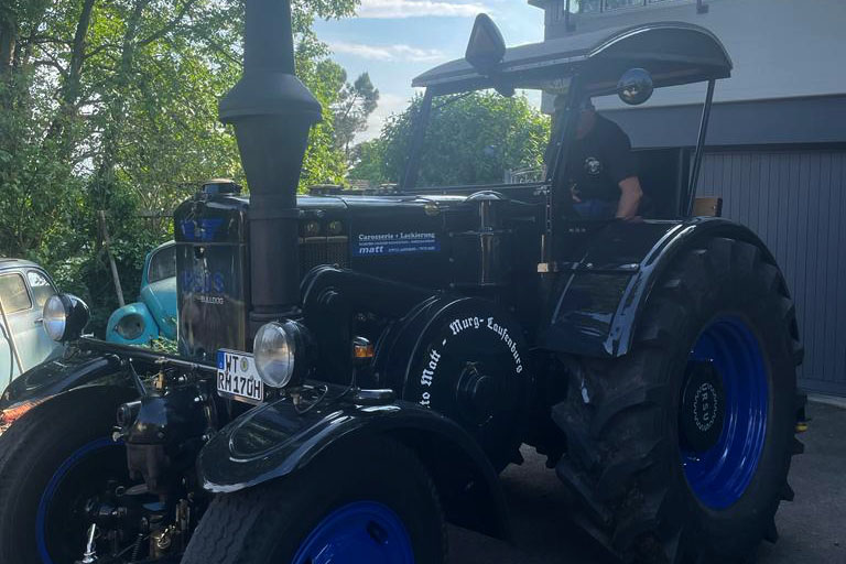 Ein schwarzer Ursus C45 steht vor einer Garage.